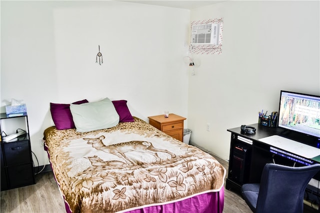 bedroom featuring light hardwood / wood-style flooring and a wall unit AC