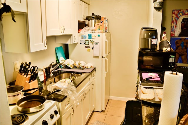 kitchen with white cabinetry, light tile patterned floors, and white appliances