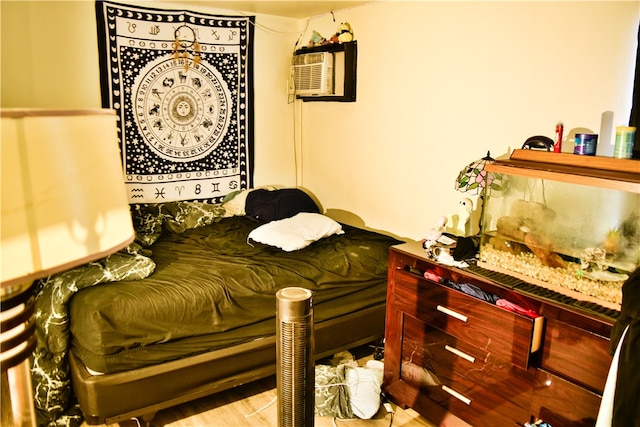 bedroom with a wall mounted AC and light hardwood / wood-style flooring