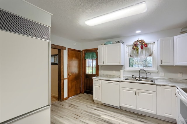 kitchen featuring white cabinets, white appliances, a wealth of natural light, and sink