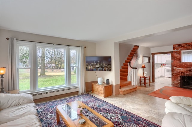 living room with wood-type flooring, a baseboard radiator, and a brick fireplace