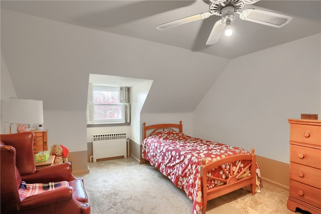 carpeted bedroom with ceiling fan, radiator, and vaulted ceiling