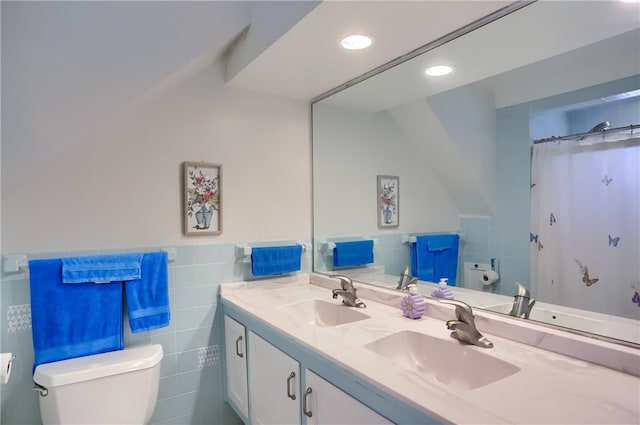 bathroom with curtained shower, vanity, tile walls, and toilet