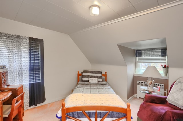 carpeted bedroom featuring radiator heating unit and vaulted ceiling