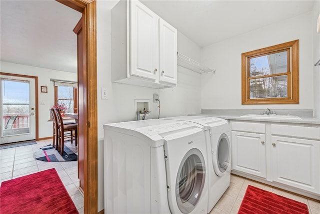 clothes washing area with washing machine and clothes dryer, sink, light tile patterned floors, and cabinets