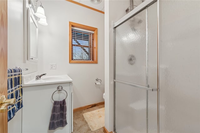 bathroom featuring a shower with door, vanity, and toilet