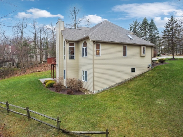 view of side of home featuring a yard and a wooden deck