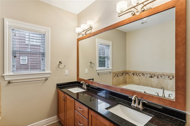 bathroom featuring vanity, a bathtub, and a healthy amount of sunlight