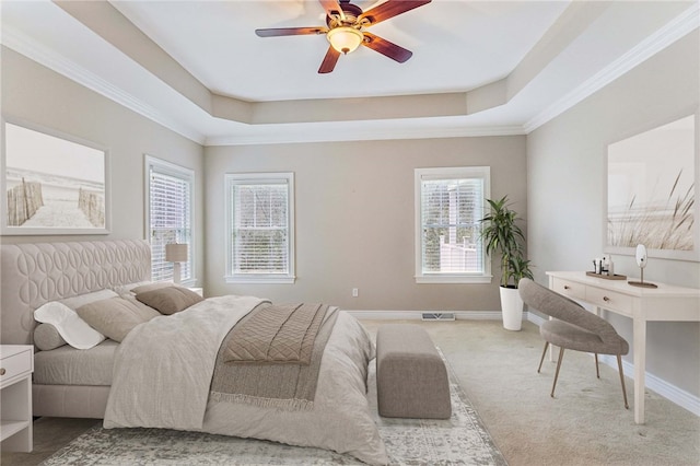 carpeted bedroom featuring a raised ceiling, ceiling fan, and crown molding