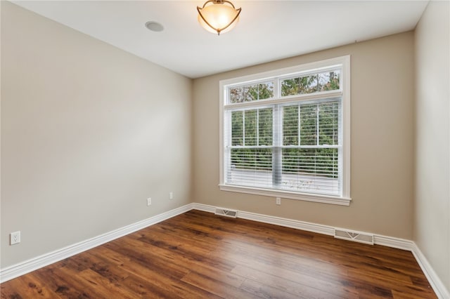 unfurnished room with dark wood-type flooring