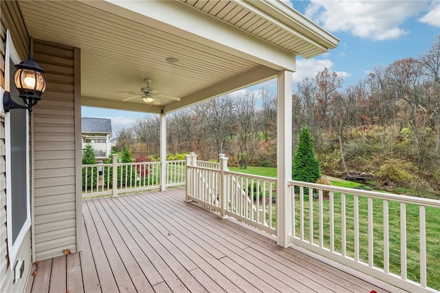 wooden terrace with ceiling fan and a yard