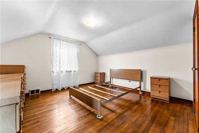 bedroom with lofted ceiling and dark hardwood / wood-style floors