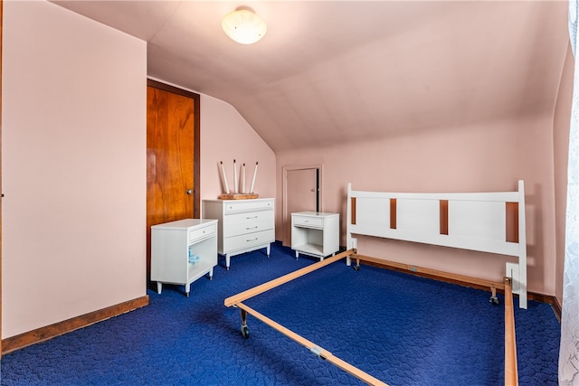 unfurnished bedroom featuring dark carpet and lofted ceiling