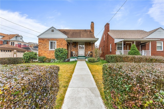 bungalow-style home with a front yard and covered porch