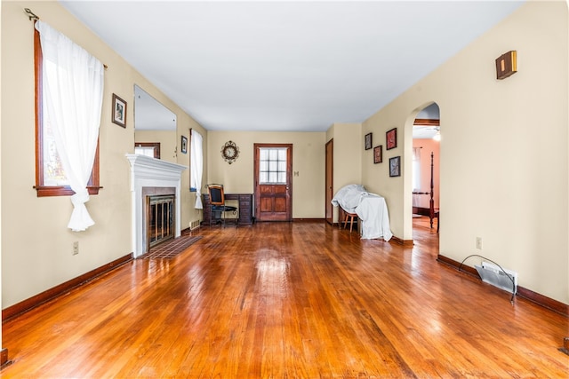 unfurnished living room with wood-type flooring and ceiling fan