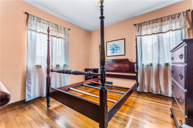 bedroom with multiple windows and light hardwood / wood-style floors