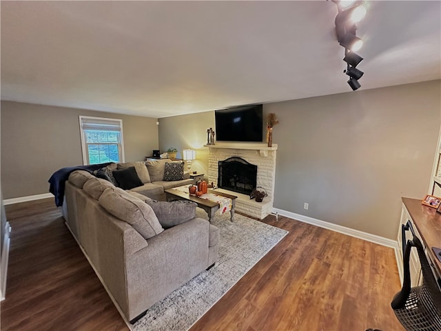 living room featuring dark hardwood / wood-style flooring and a brick fireplace