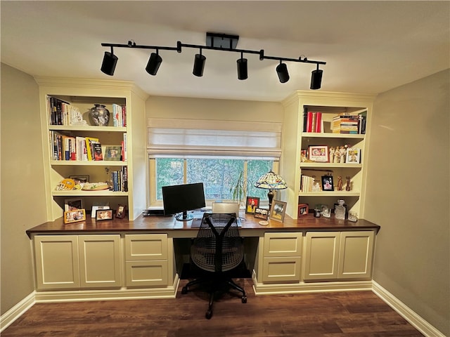 office area featuring built in desk, dark wood-type flooring, and track lighting