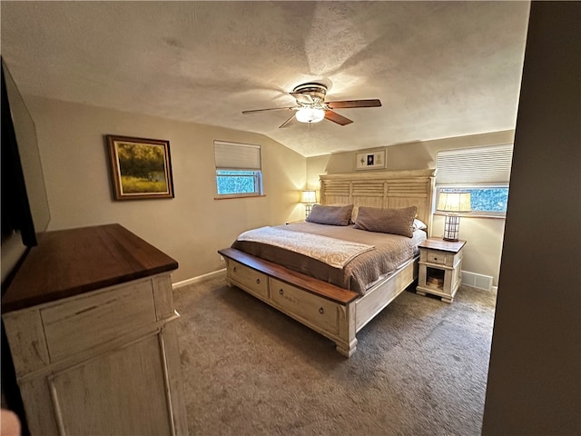 carpeted bedroom featuring a textured ceiling, multiple windows, ceiling fan, and vaulted ceiling