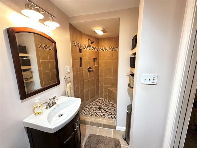 bathroom with tiled shower, vanity, and tile patterned floors