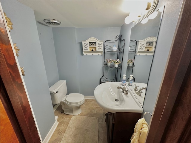 bathroom with tile patterned flooring, vanity, and toilet