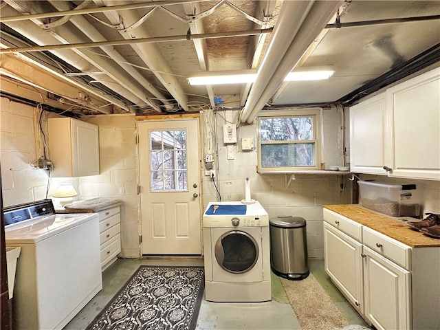 laundry room featuring cabinets, washing machine and dryer, and a wealth of natural light