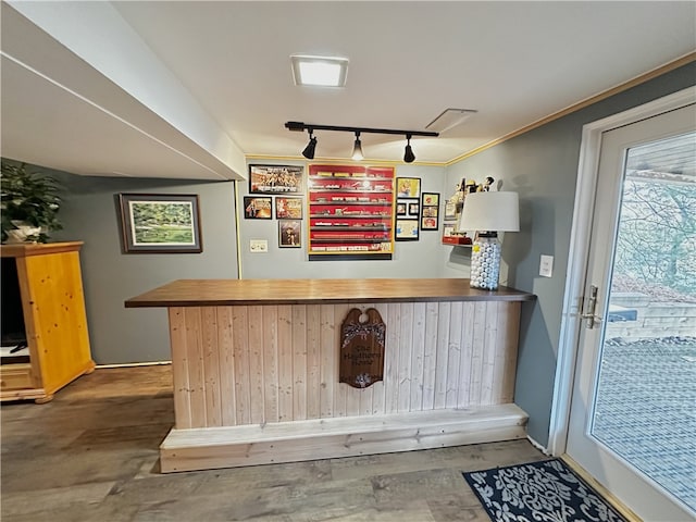 bar featuring rail lighting and dark hardwood / wood-style floors