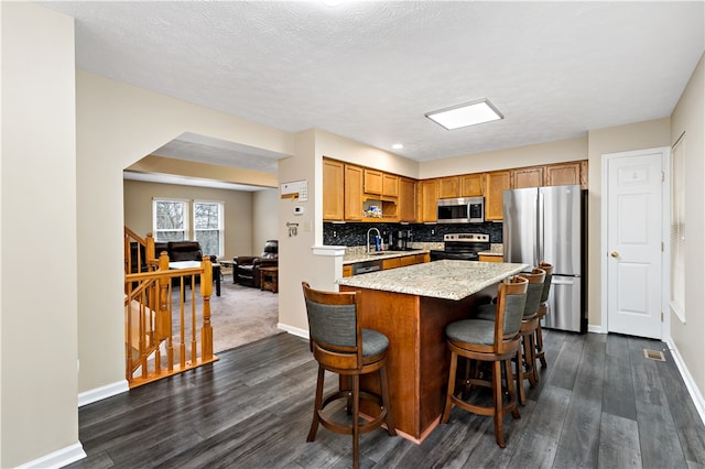 kitchen with sink, decorative backsplash, a textured ceiling, dark hardwood / wood-style flooring, and stainless steel appliances