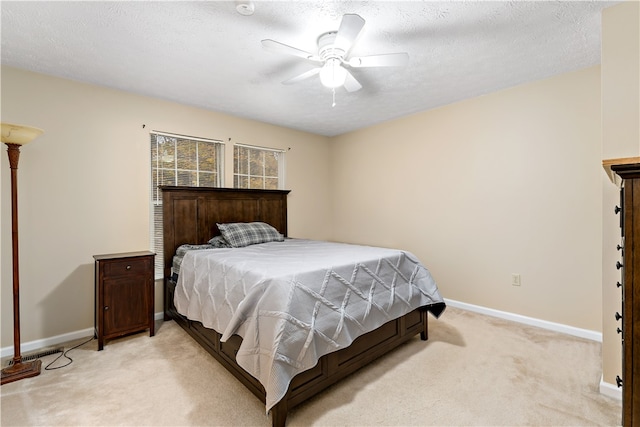 bedroom with a textured ceiling, light colored carpet, and ceiling fan