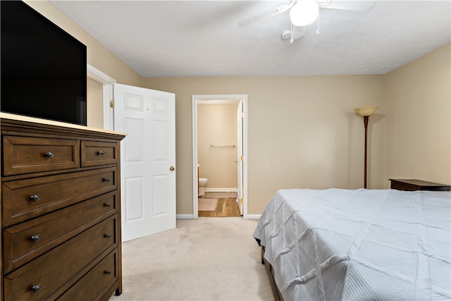 carpeted bedroom with ceiling fan and ensuite bathroom