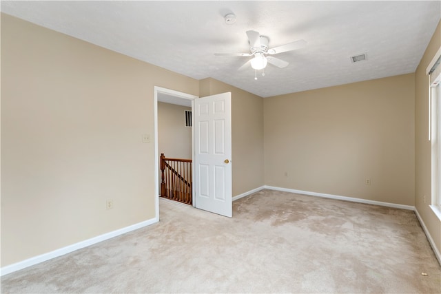 carpeted spare room featuring a textured ceiling and ceiling fan