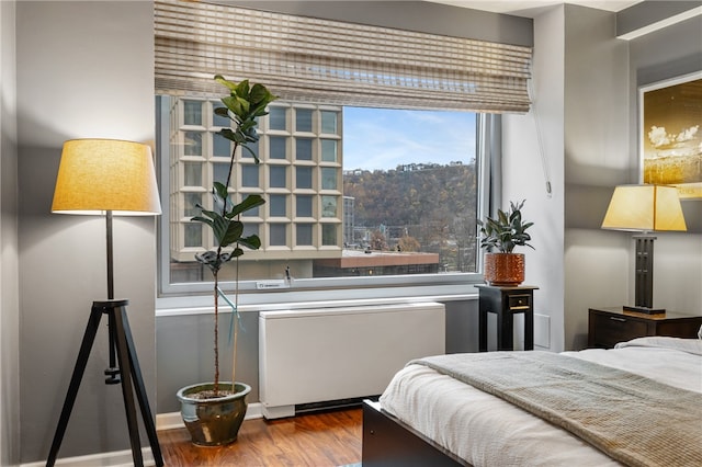 bedroom featuring hardwood / wood-style flooring and radiator