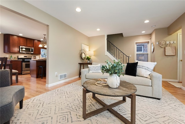 living room featuring light hardwood / wood-style floors and an inviting chandelier