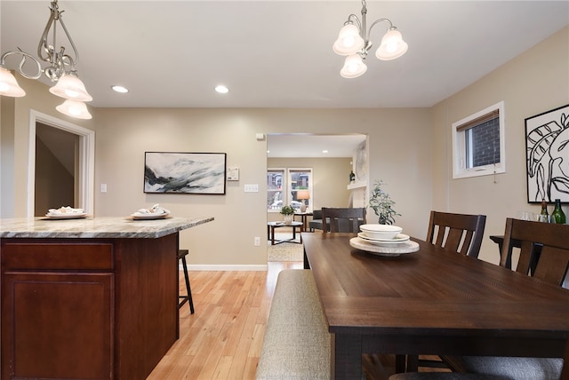 dining space with a chandelier and light hardwood / wood-style floors