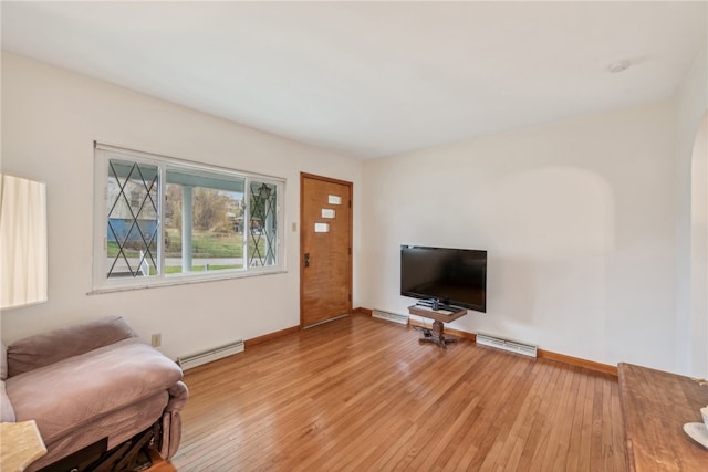 living room with light hardwood / wood-style floors and a baseboard heating unit