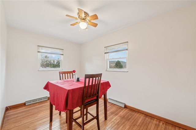 dining space featuring light wood-type flooring, a baseboard radiator, ceiling fan, and a healthy amount of sunlight