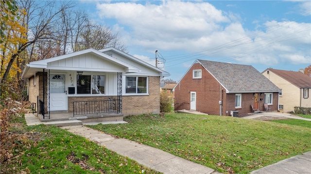 bungalow-style home featuring a porch, central AC, and a front lawn