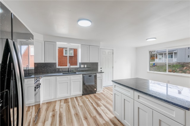 kitchen featuring white cabinets, dishwasher, a healthy amount of sunlight, and fridge