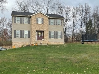 view of front facade featuring a front yard and a trampoline