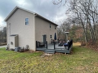 back of house featuring a deck and a lawn