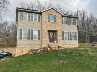 view of front of property featuring a trampoline and a front yard