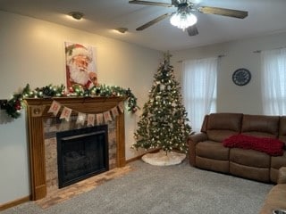 living room with carpet floors, ceiling fan, and a tiled fireplace