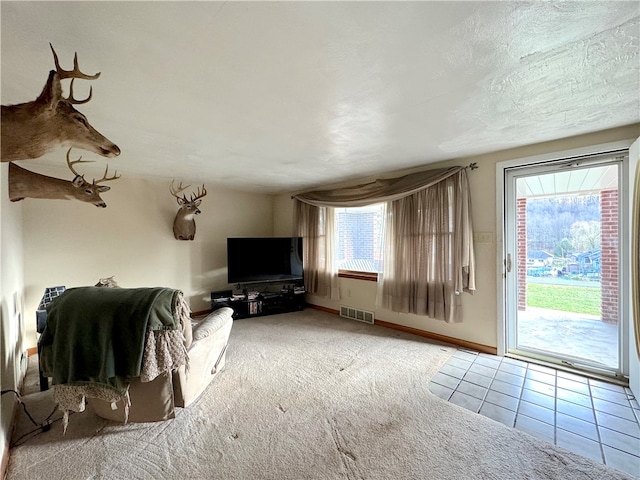 unfurnished living room featuring tile patterned floors, a wealth of natural light, and a textured ceiling