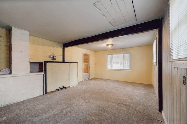 interior space with beam ceiling, carpet floors, and wooden walls