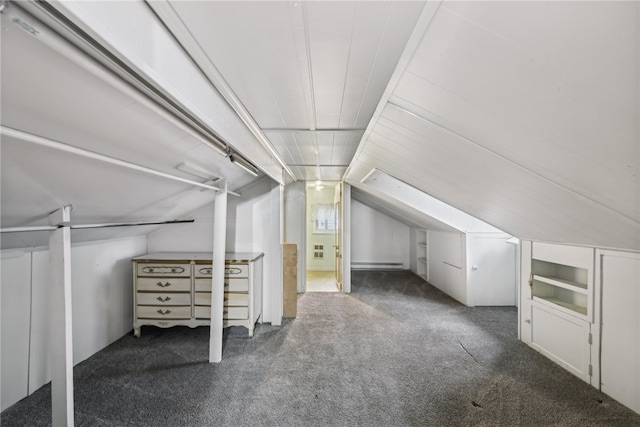 additional living space featuring dark carpet and vaulted ceiling