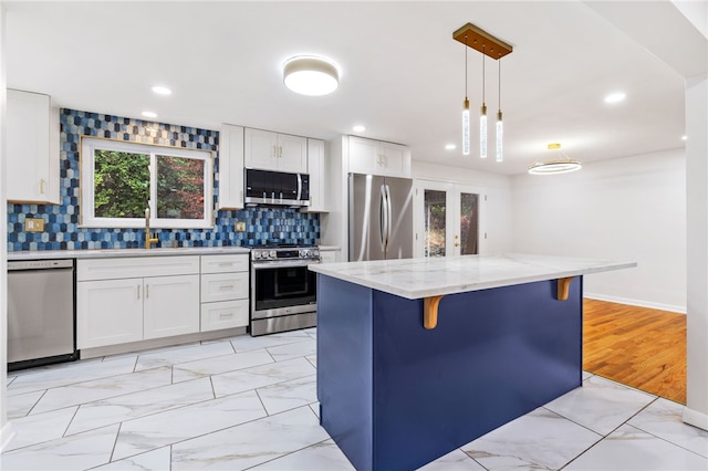 kitchen with white cabinets, a kitchen island, and stainless steel appliances