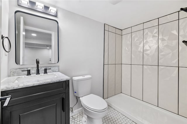 bathroom featuring tile patterned flooring, vanity, toilet, and a tile shower