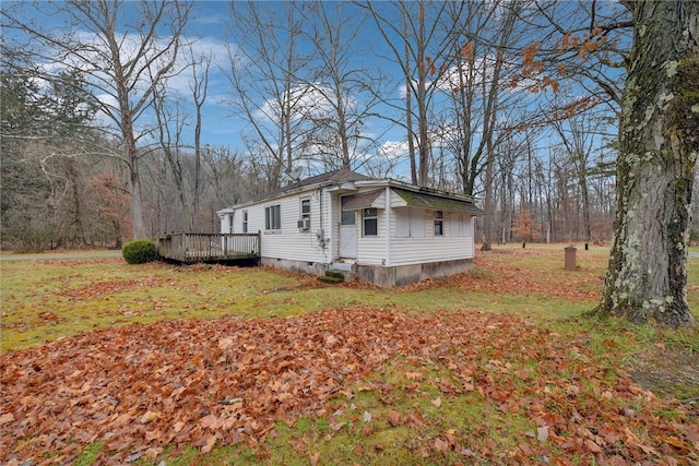 view of home's exterior featuring a lawn and a wooden deck