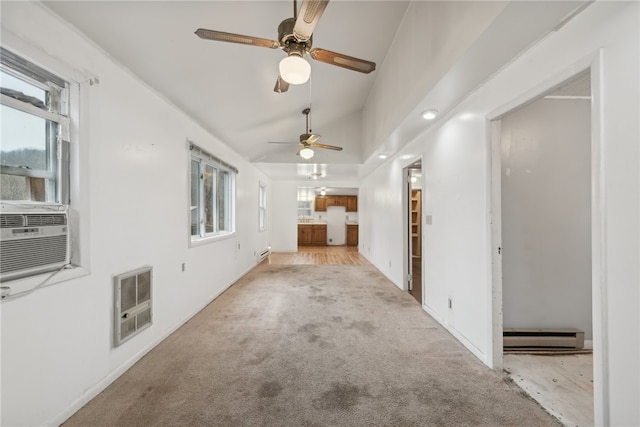 unfurnished living room with baseboard heating, heating unit, plenty of natural light, and vaulted ceiling