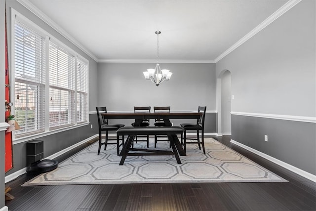 dining room featuring ornamental molding, wood-type flooring, and a notable chandelier